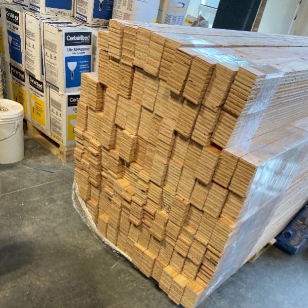 A wrapped stack of plywood backing cut into strips